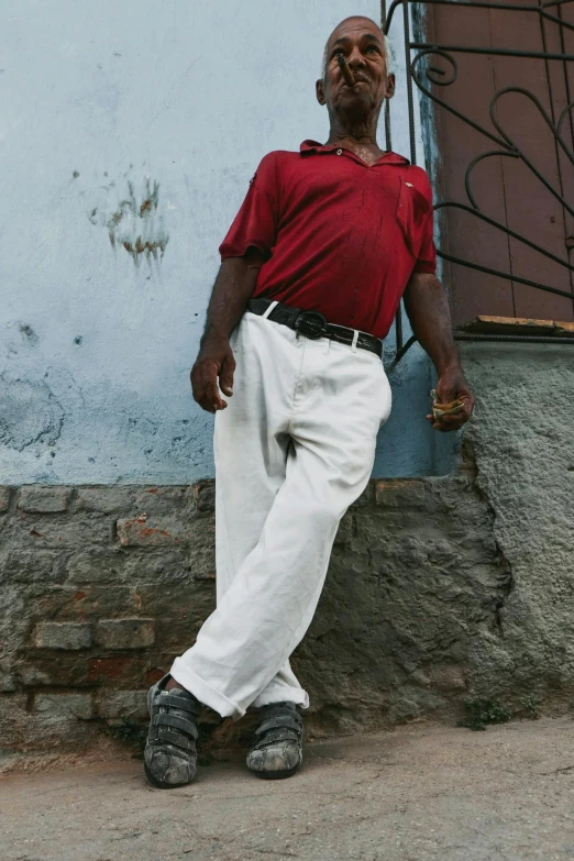 a man is leaning up against the side of a building