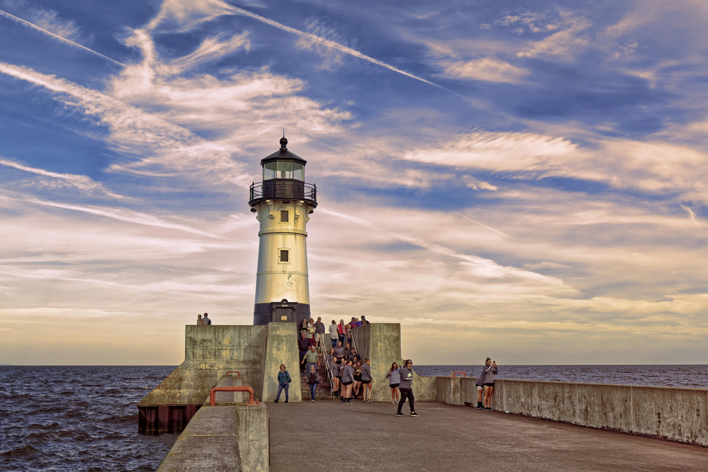 a lighthouse in the middle of the ocean on a pier