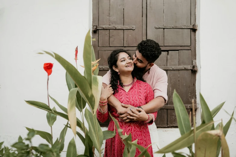 man holding women while she hugging her face in front of an open door