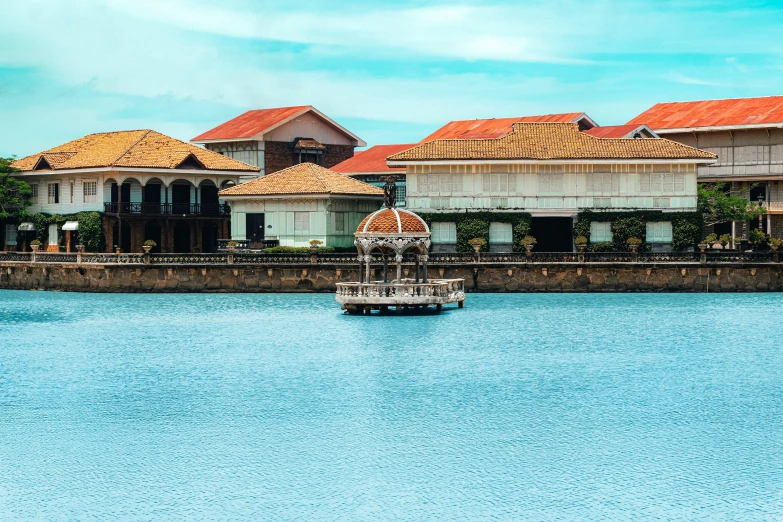 a lake in front of two buildings with a boat sitting on it