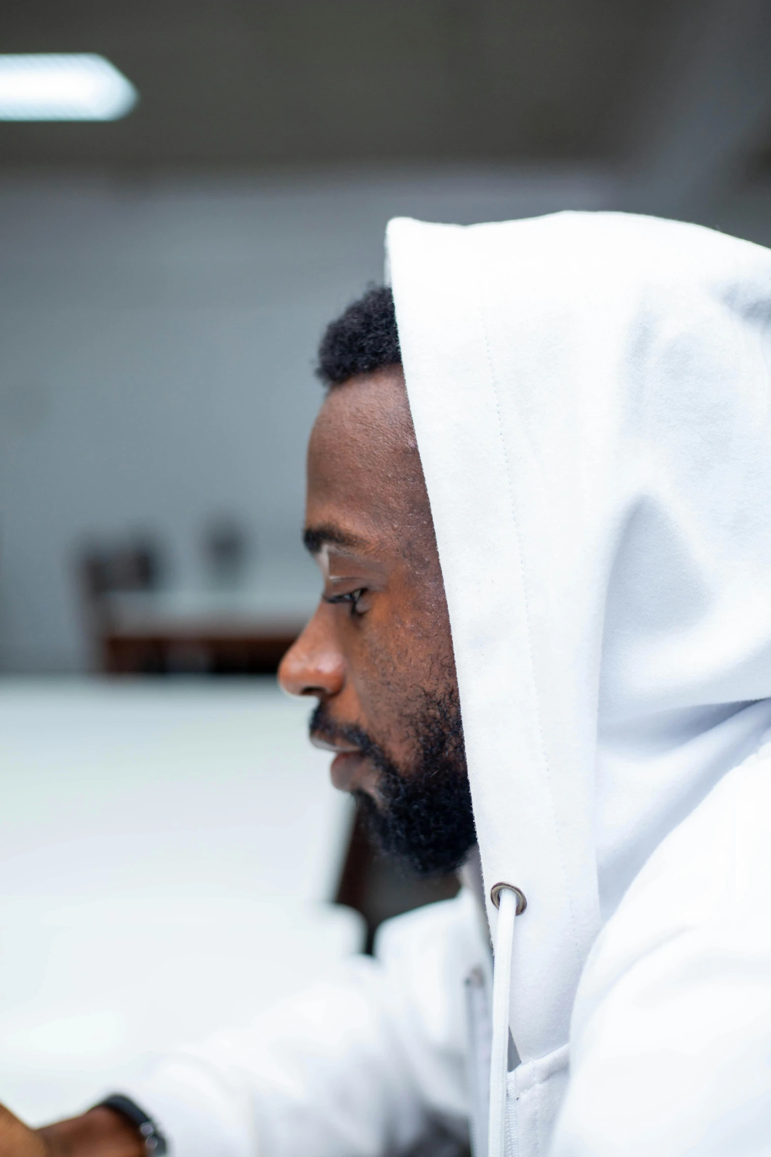 a man wearing white sweats with a hood over his head