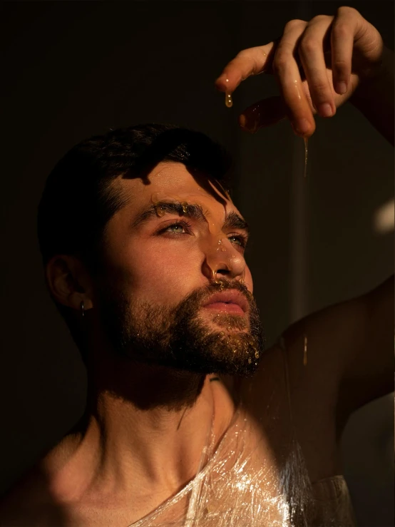 a man in a tank top with his hand on his forehead