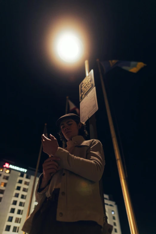 woman in winter coat holding cell phone at night