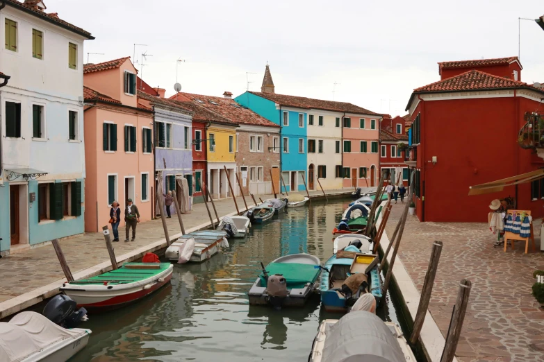several boats are docked in a canal next to colorful buildings