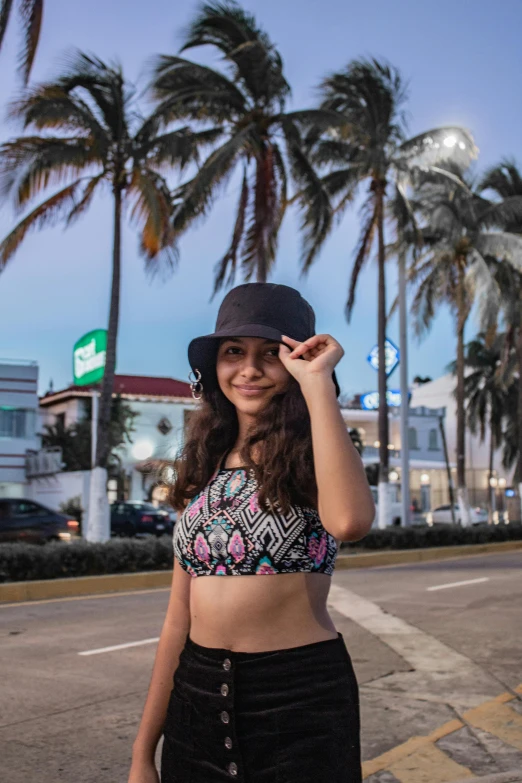 girl posing on the side of the road with palm trees in background