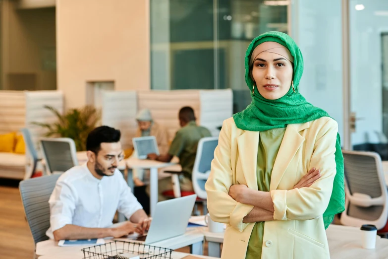 a woman with green headscarf in an office setting