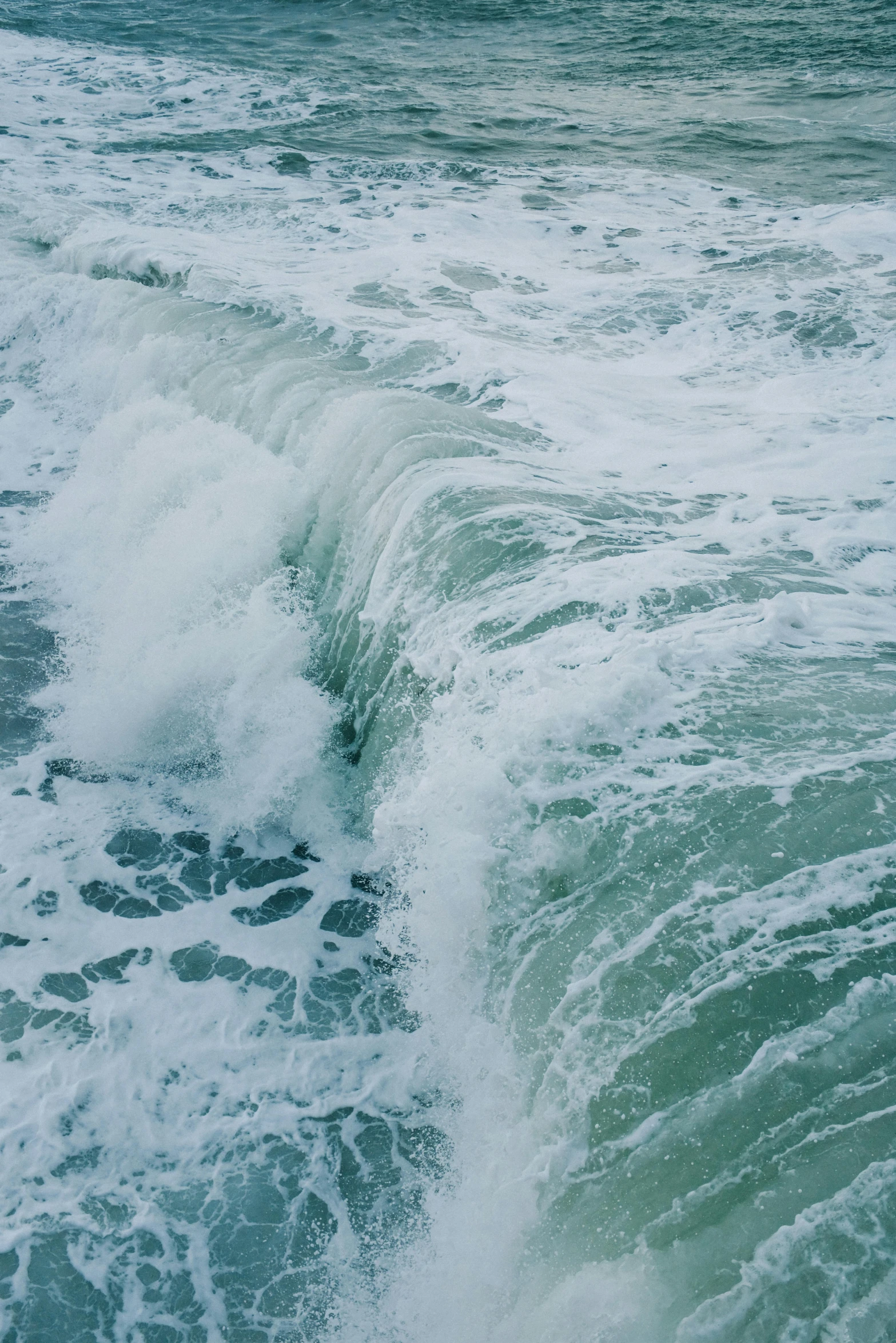 the water has a wave coming toward the shore