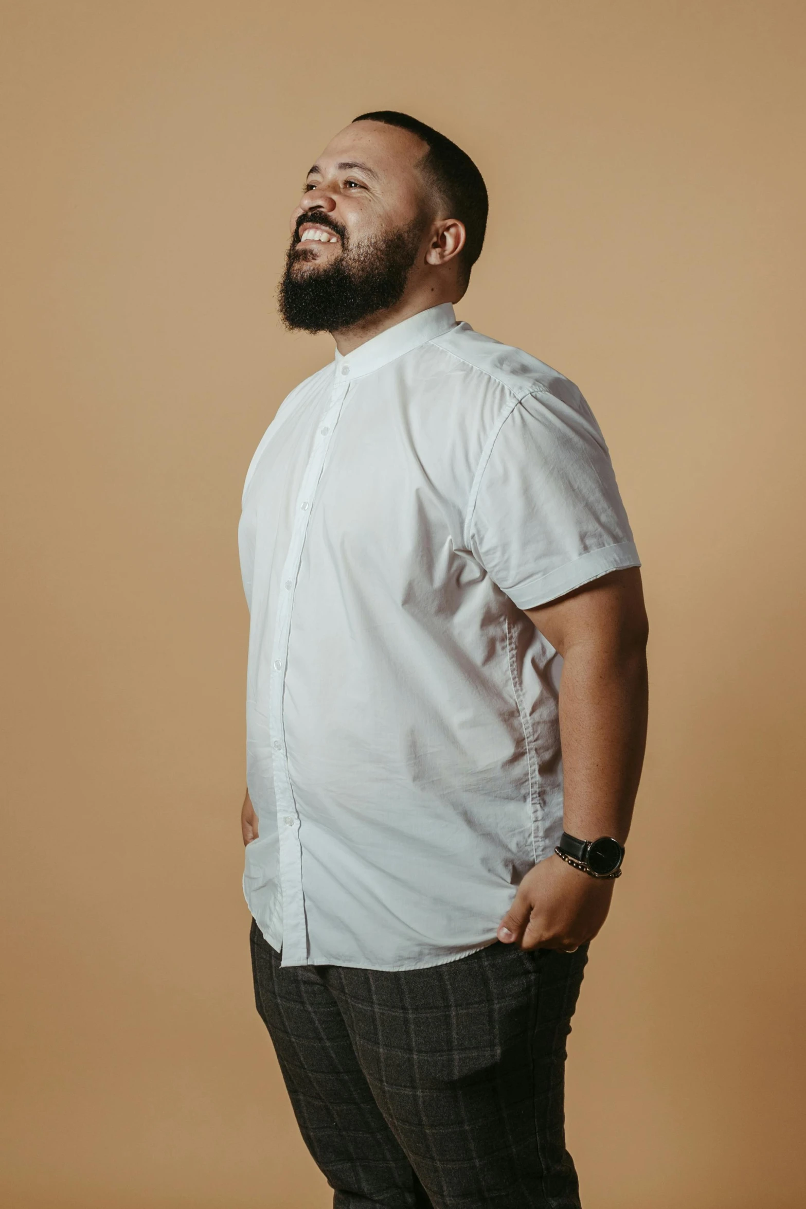 a man wearing a shirt and pants smiling