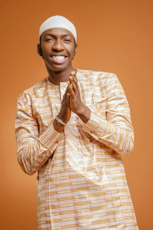 a man in african attire clapping with his hands