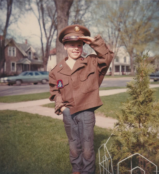 a boy in a red uniform is standing outside