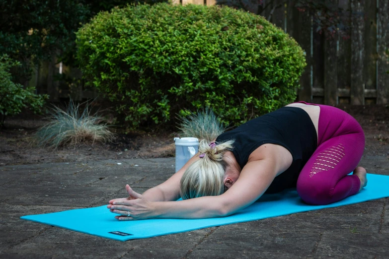 a woman is doing yoga outside on her mat