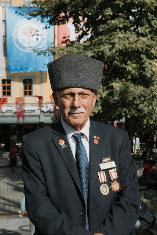 an older man in uniform stands in front of a building