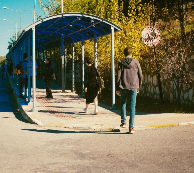 a man standing on a side walk with his skateboard