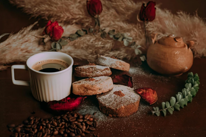 coffee and doughnuts sit on a surface with dried flowers