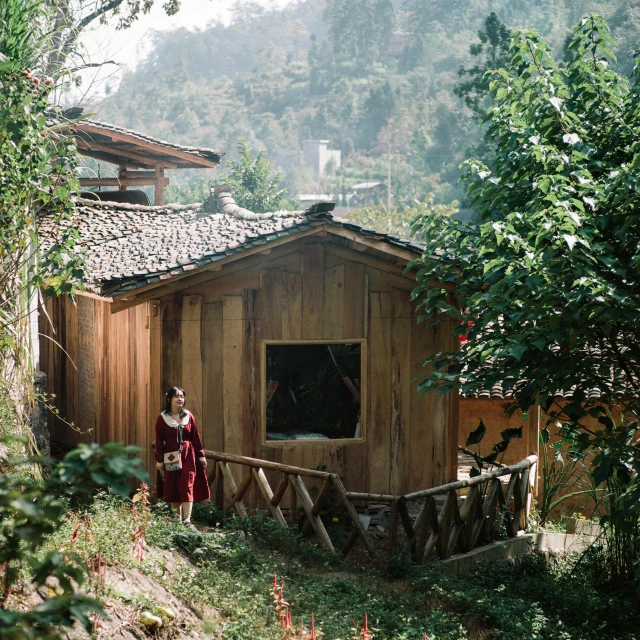 a person in traditional attire near a small wooden building