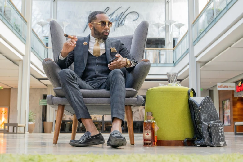 a man in a suit and tie sitting on a chair with luggage