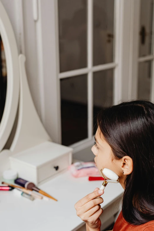 a woman looking in a mirror while shaving her face