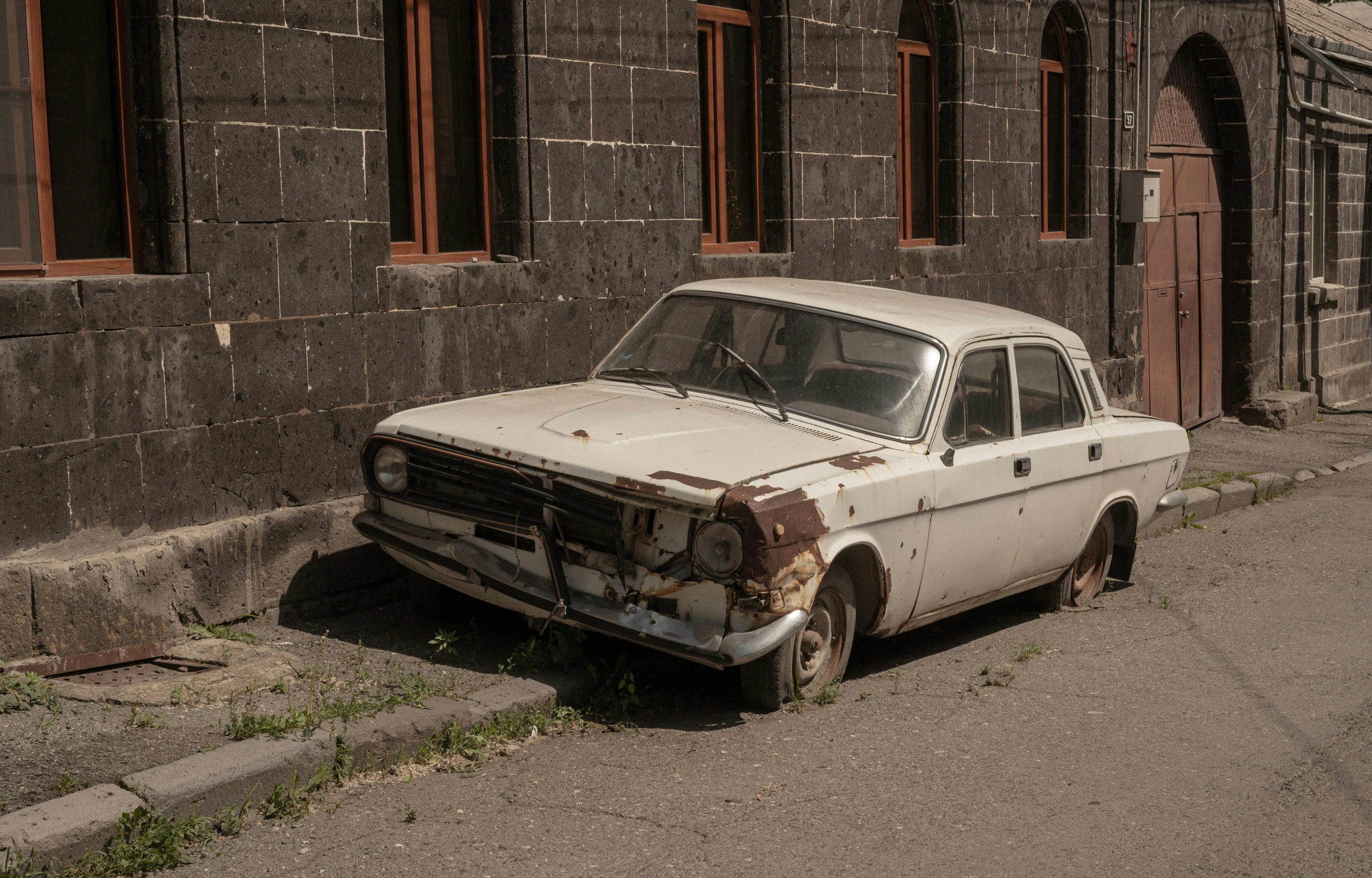 an old car sitting on the side of the street