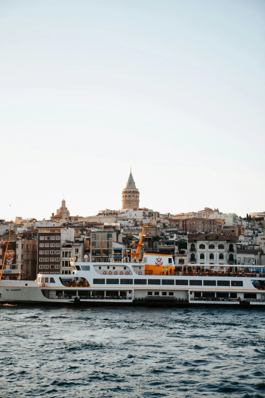 two ships parked on the shore of a bay in front of some buildings