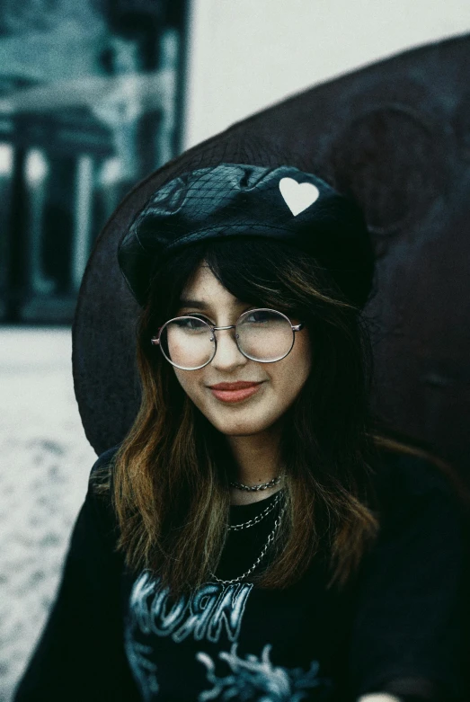a woman with glasses and hat poses for the camera