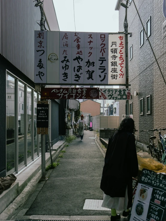 there are signs above this sidewalk in a foreign city