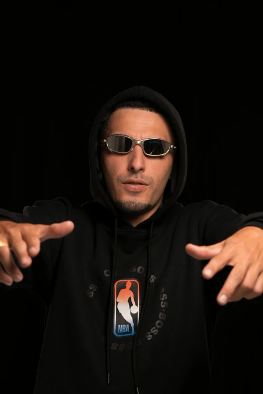 a man in black hoodie pointing at soing