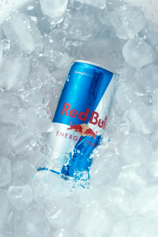 a red bull energy drink is sitting in some ice