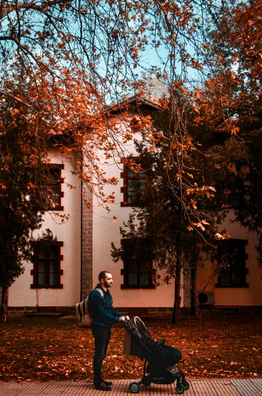 man hing stroller near home during fall