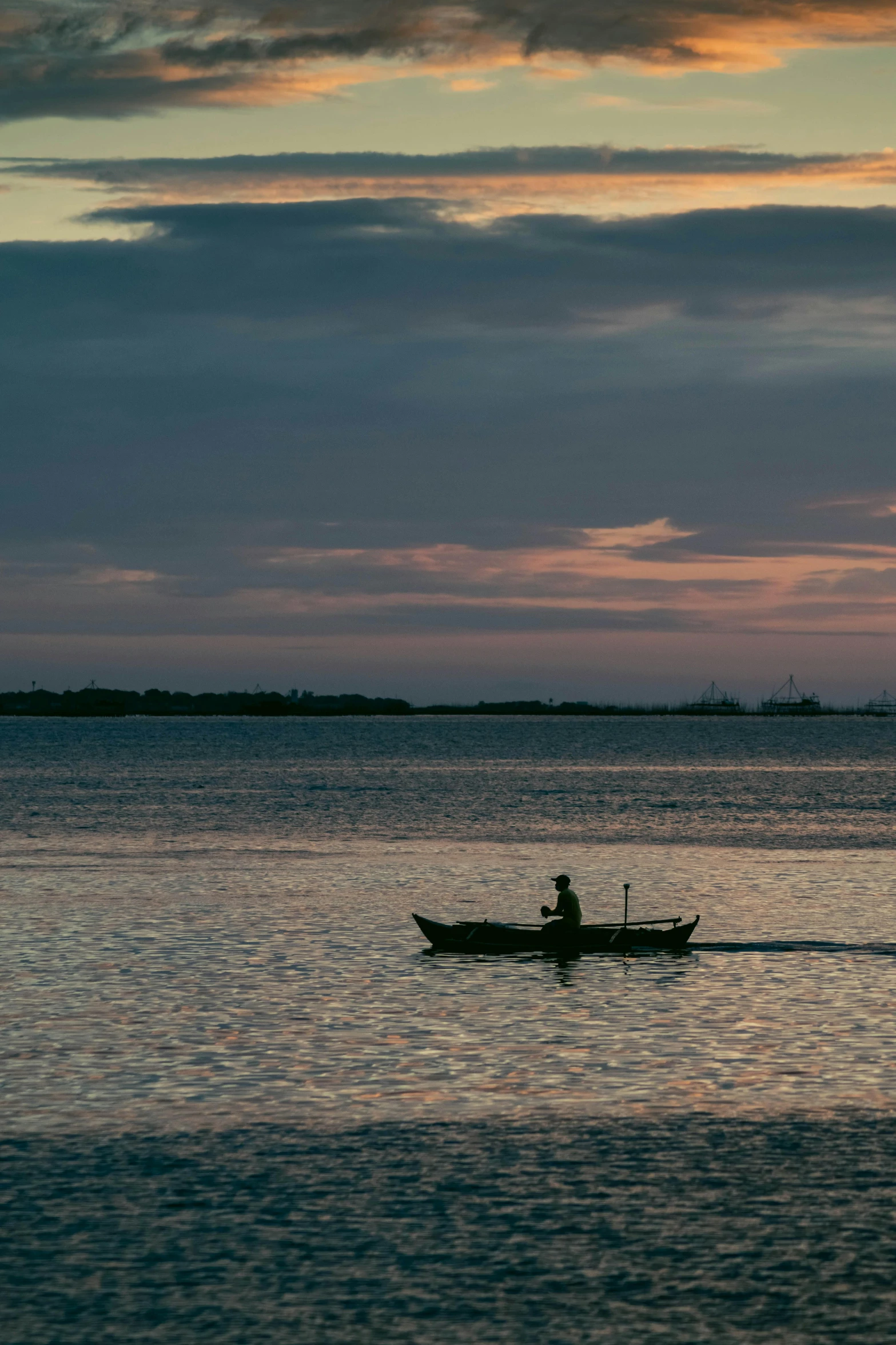 a man is canoeing in the ocean near some trees