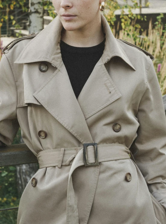 woman wearing coat in front of building