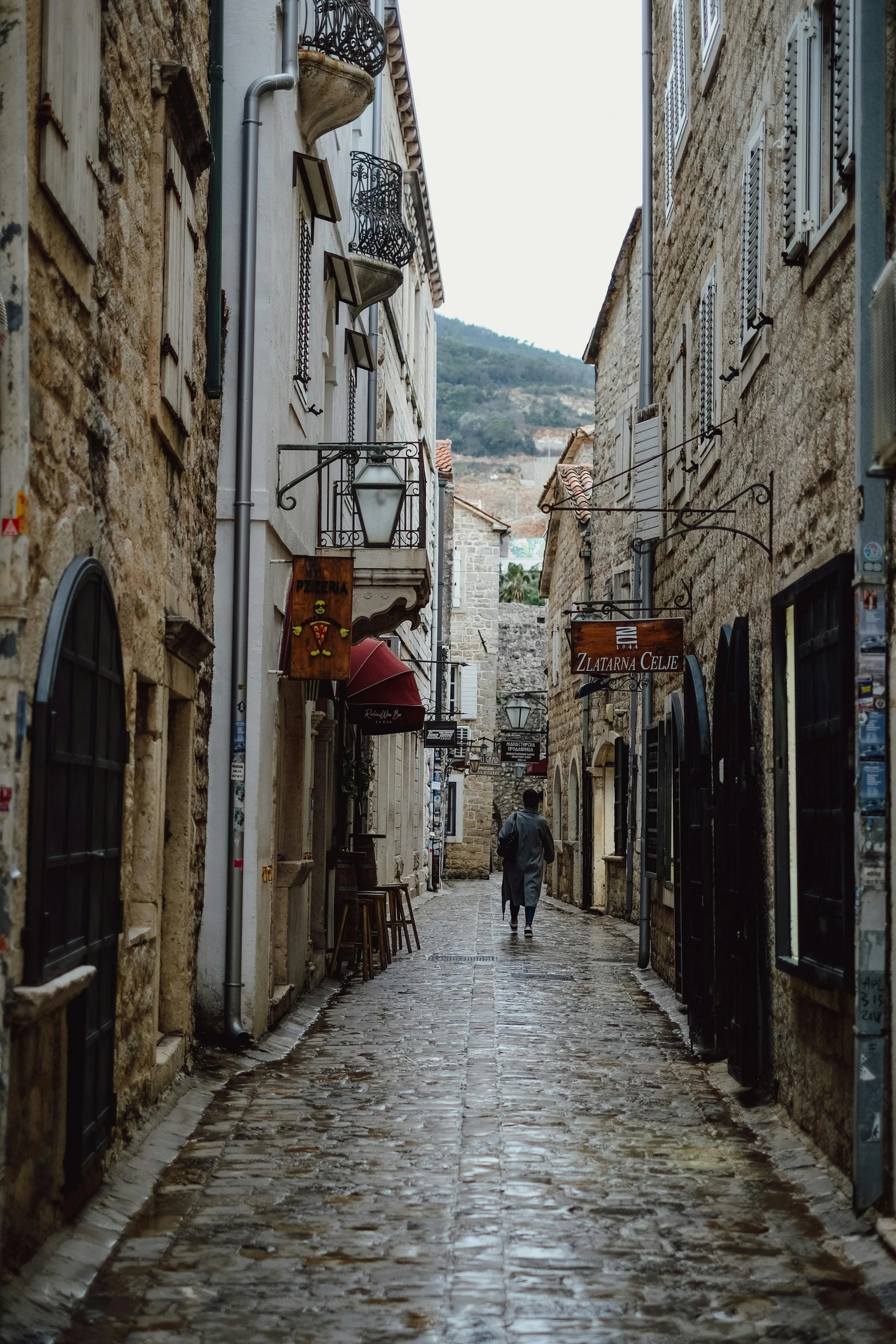 the two men are walking in the narrow alley way