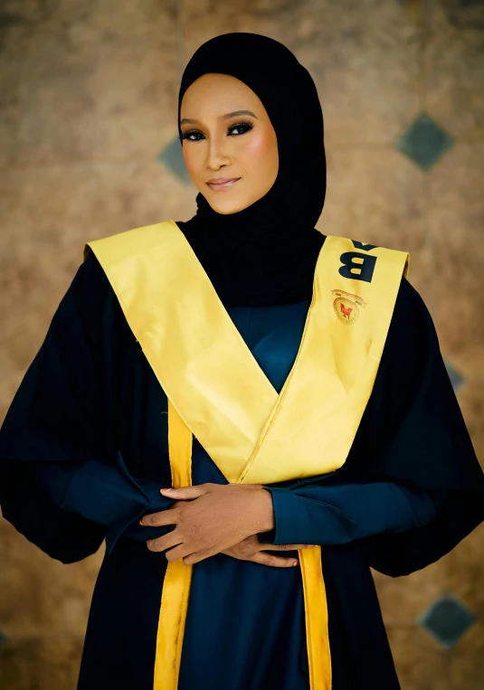 a woman wearing a scarf and dress stands by herself