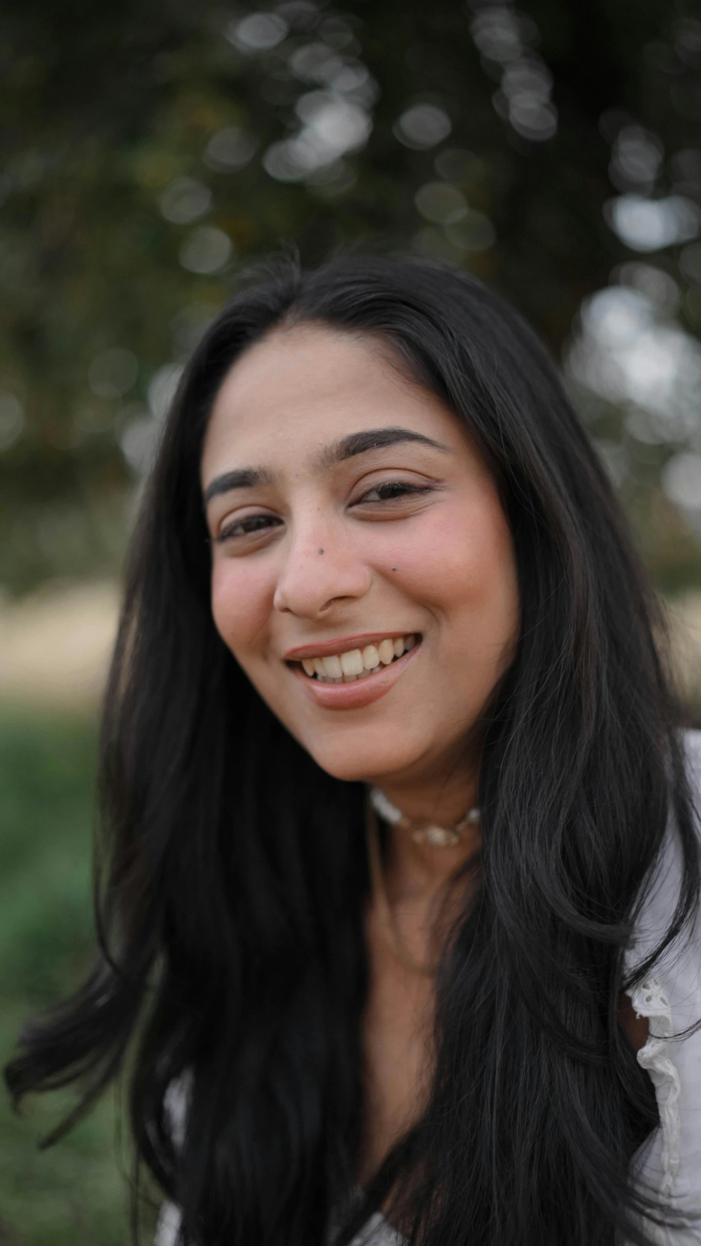 a woman that has long black hair and smiling