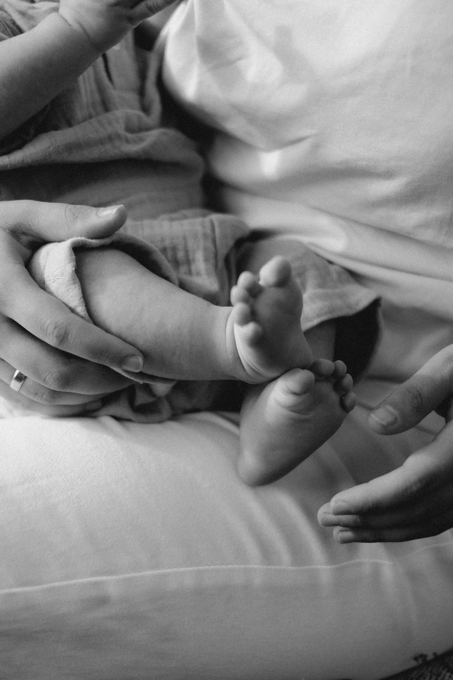 a black and white image of an infant holding its mother