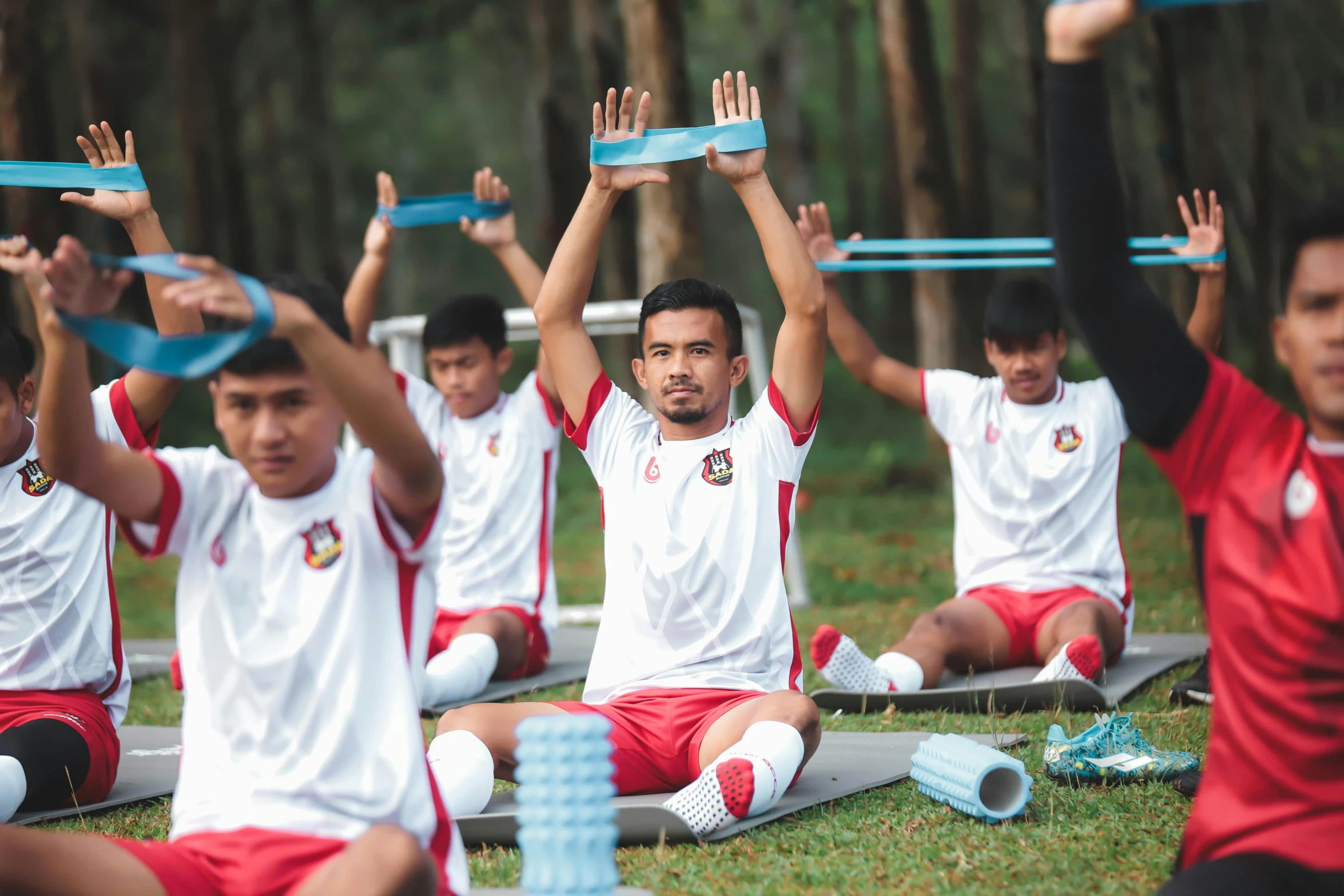 young men are doing yoga exercises on mats with their arms in the air