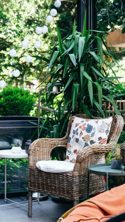 a wicker chair on the patio next to a table