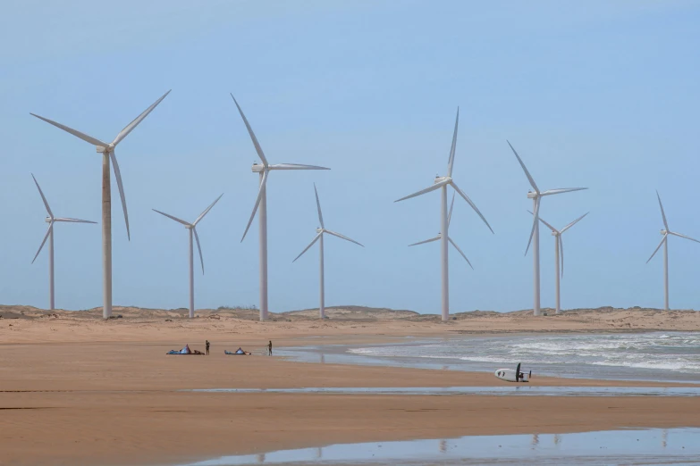 a number of wind turbines at the beach