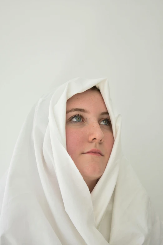 a person covered in white fabric standing