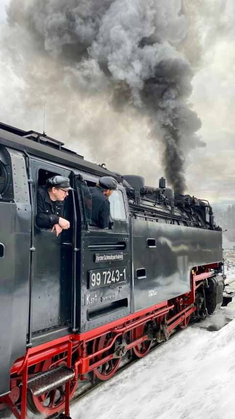 a man sitting in the seat of a steam locomotive