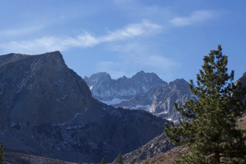 a view of some very mountains by the trees