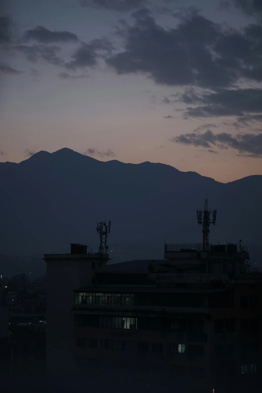 the sunsets in front of the mountains as viewed from a building