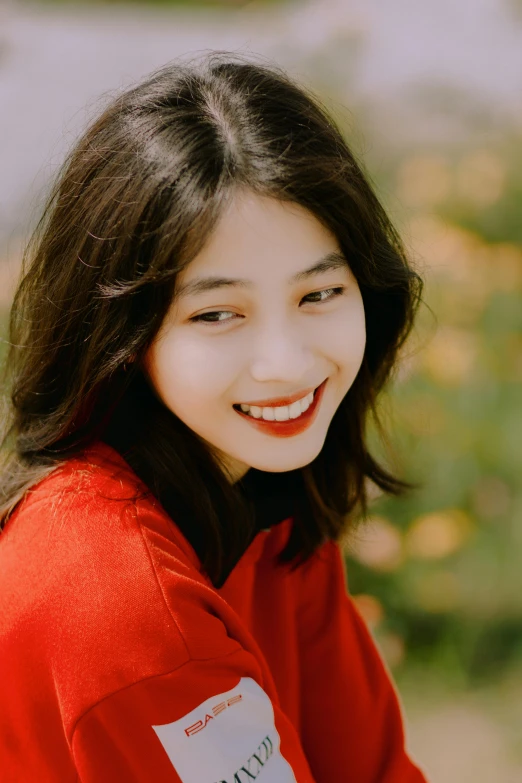 a smiling young woman wearing red shirt