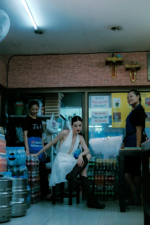 two women standing in front of a store full of soda cans