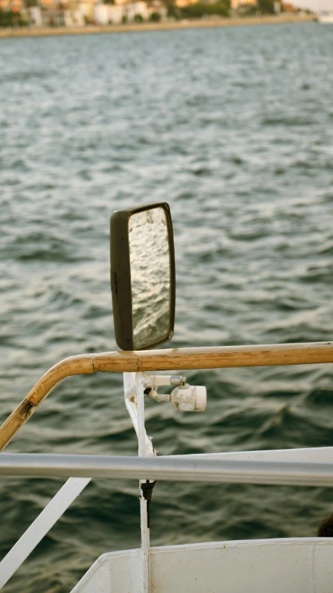 a mirror reflecting the water in the back of a boat