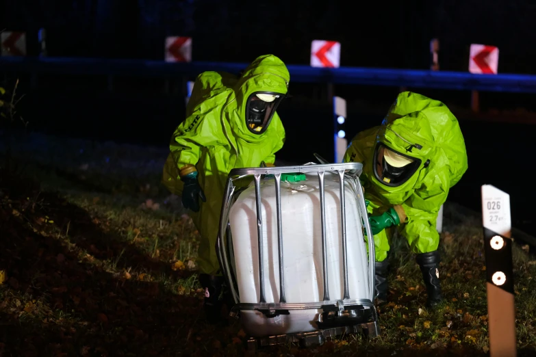 two men in neon green are going down the hill near the trashcan