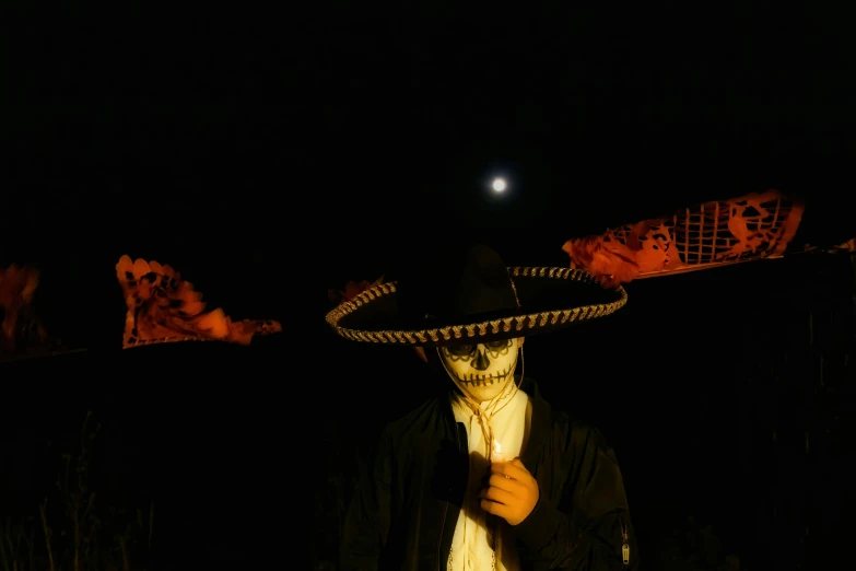 person with large hat standing in the dark