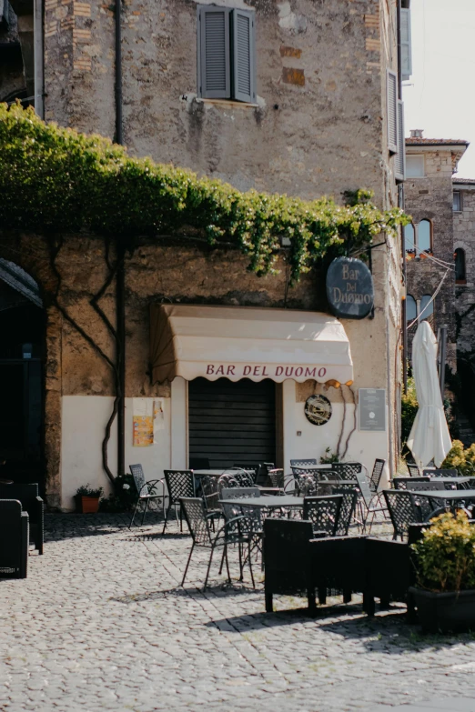 outdoor dining tables and chairs on a cobblestone patio