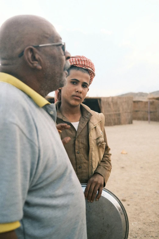 man holding a drum while standing next to woman