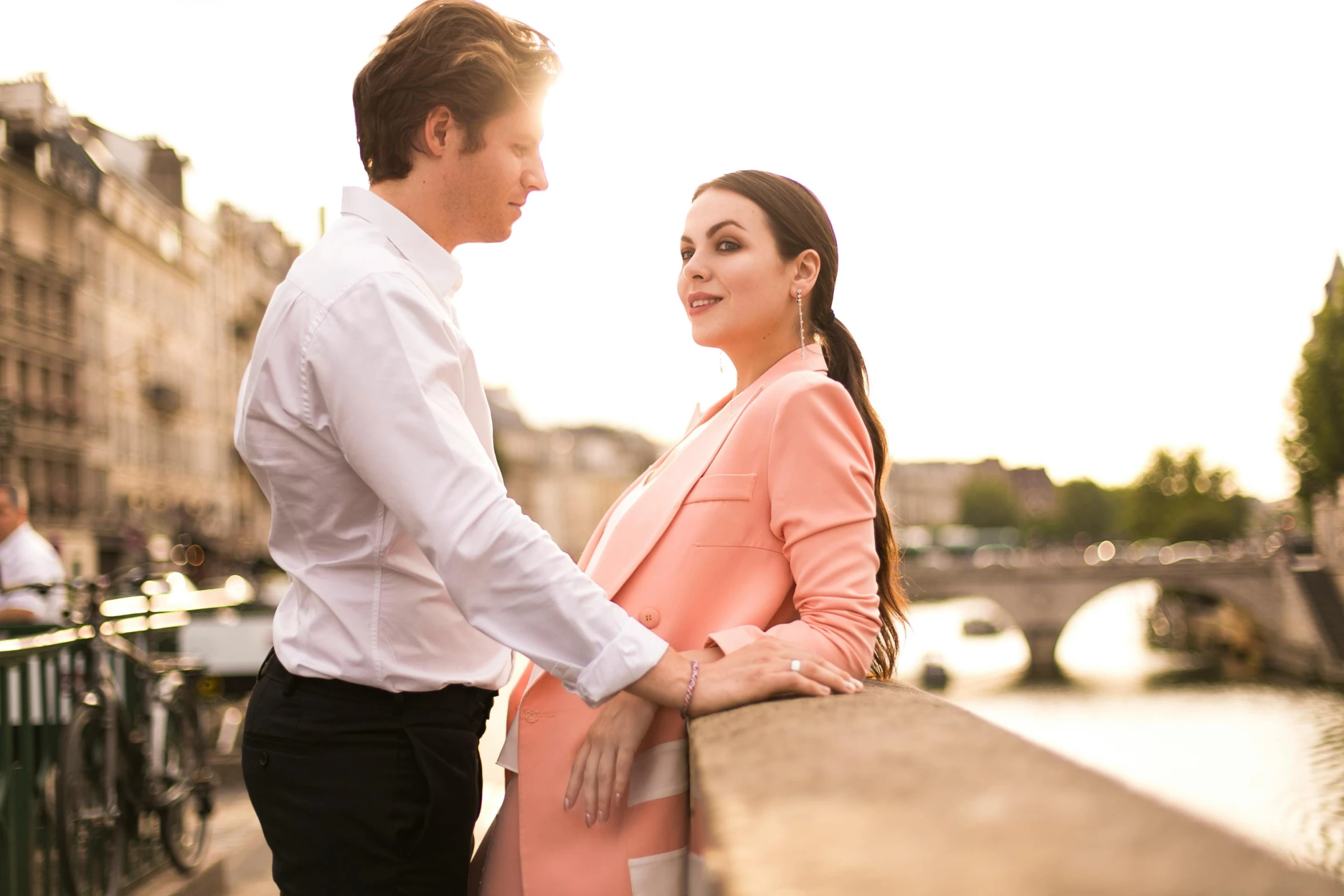 the woman is standing by the man on the bridge