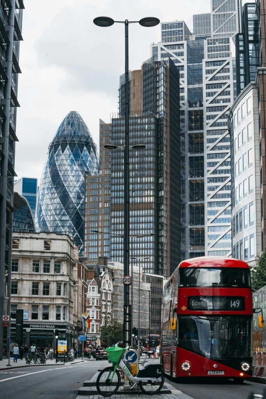 red double decker bus driving down a street in london